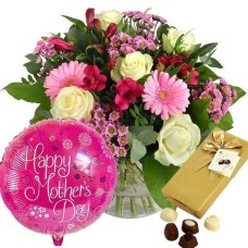 Fleurs mélangées dans un vase, boîte de chocolat et un ballon
